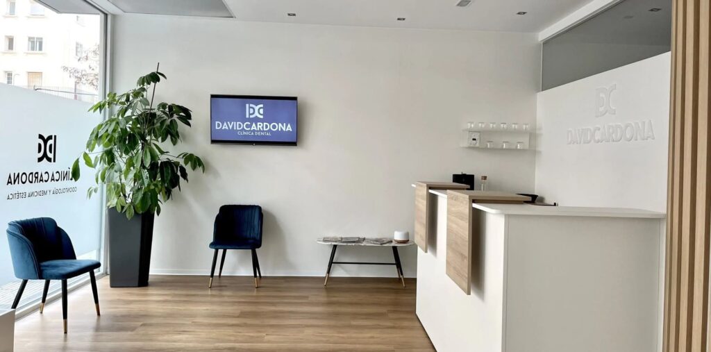 Zona de espera luminosa de David Cardona Clínica Dental Zaragoza, sillas azules y diseño moderno