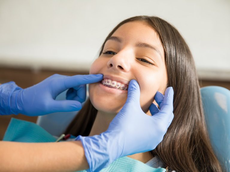 Paciente adolescente con brackets durante una revisión de ortodoncia